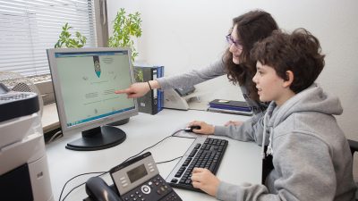 Jugendliche schauen auf einen Rechner